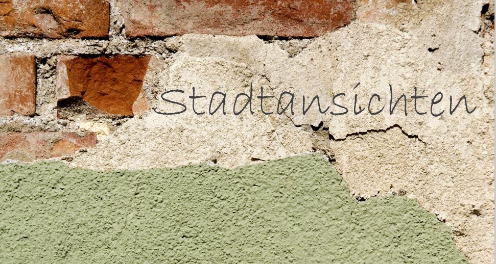 Rote Ziegelwand mit weißem und grünen abgeblätterten Außenwanddputz. Auf dem weißem Wandputz steht das Wort Stadtansichten.